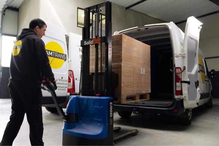 Koerier laadt een pallet in zijn camionette met een heftruck