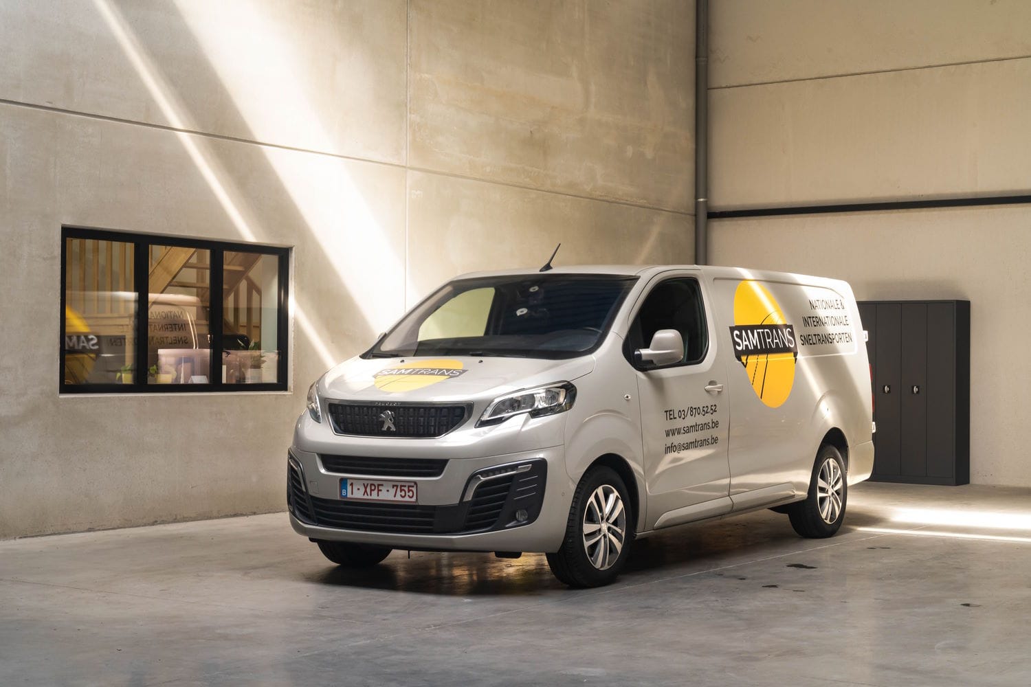 Het type medium van express transport SamTrans zijnde een peugeot expert met reclame op