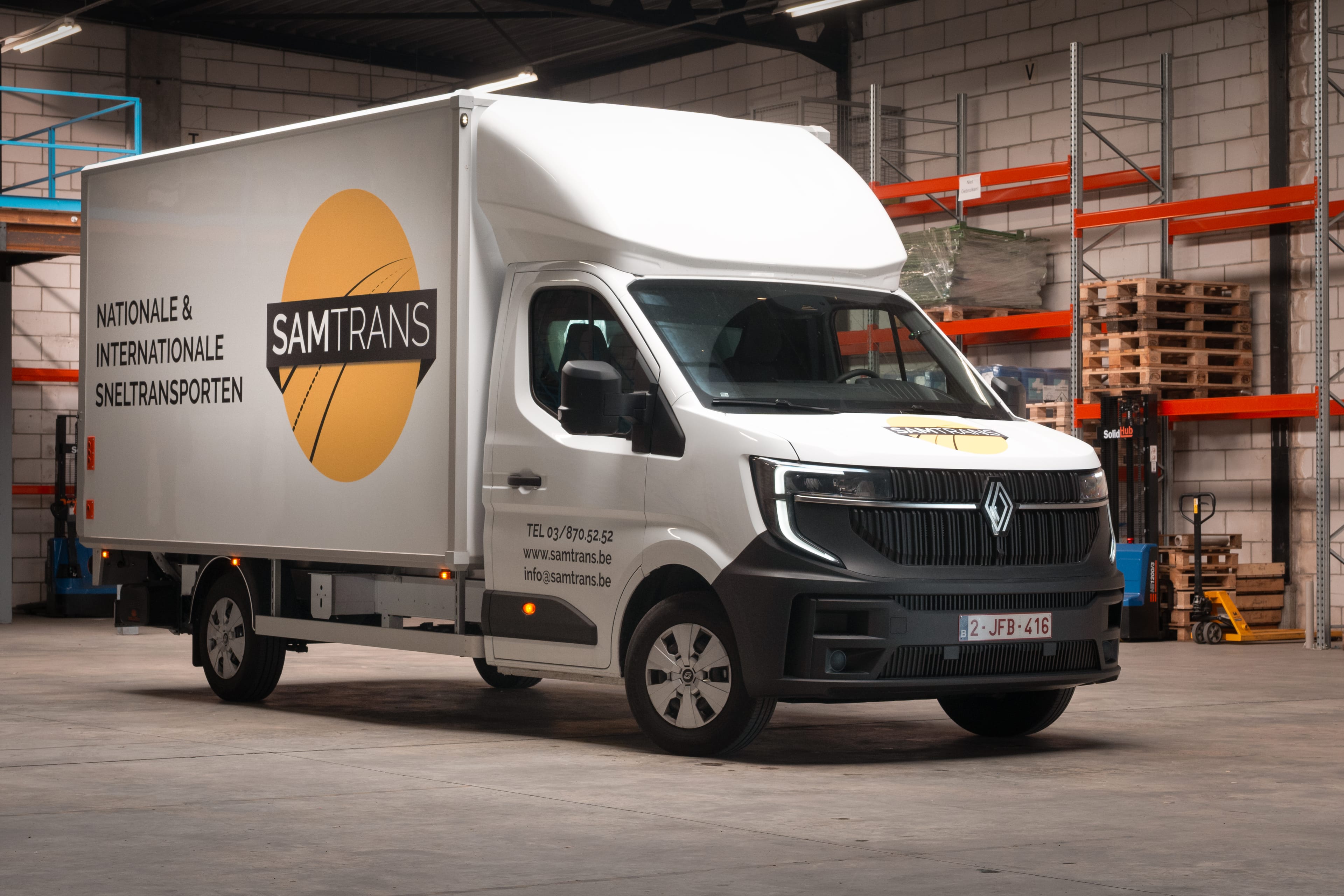 Het type XL van sprint transport SamTrans zijnde een Renault master omgebouwd met laadbak en laadklep met reclame op